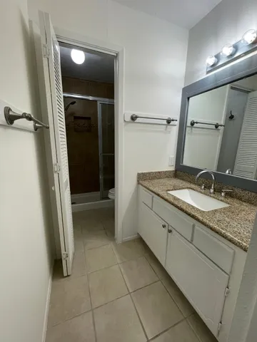 a bathroom with a granite countertop sink and a mirror