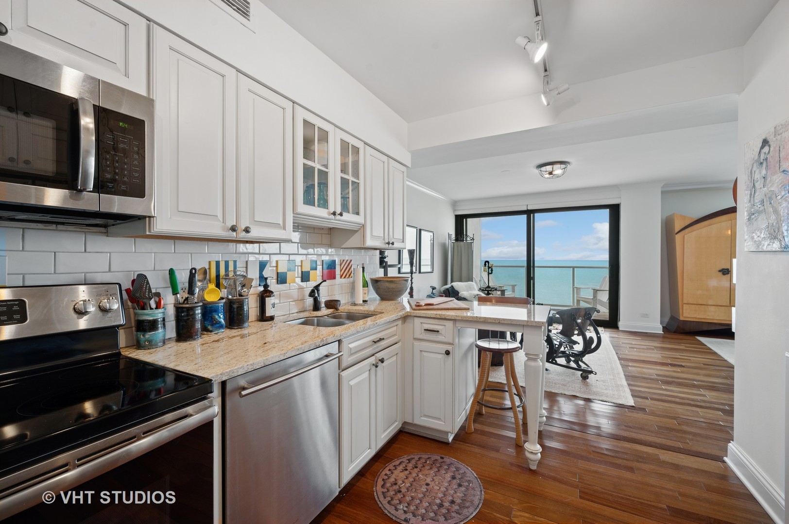 1616 Sheridan Road, Unit 10C Wilmette, IL 60091 - Photo 10 of 15 a open kitchen with stainless steel appliances granite countertop a stove top oven a sink dishwasher and white cabinets with wooden floor