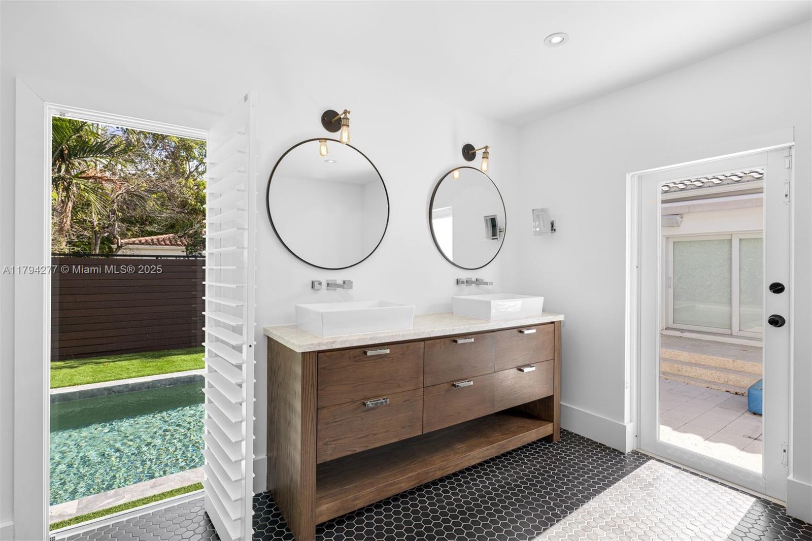 712 Northeast 72nd Street Miami, FL 33138 - Photo 11 of 35 a bathroom with a double vanity sink and a mirror
