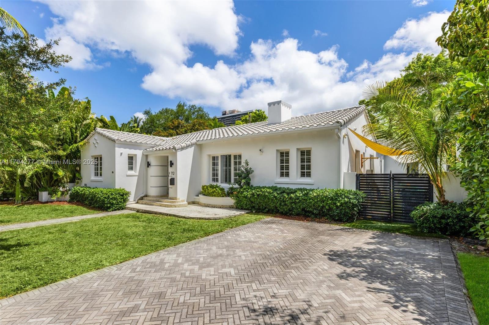712 Northeast 72nd Street Miami, FL 33138 - Photo 18 of 35 a front view of a house with a yard and garage
