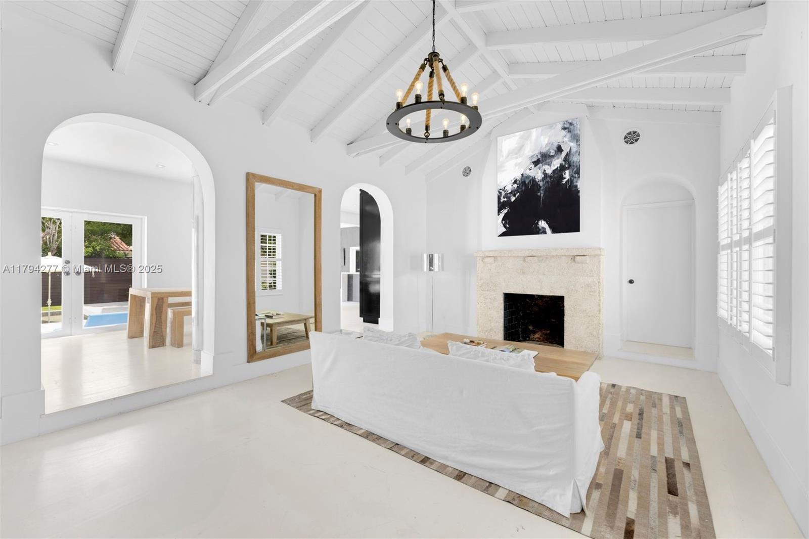 712 Northeast 72nd Street Miami, FL 33138 - Photo 4 of 35 a view of a livingroom with a fireplace a chandelier and windows