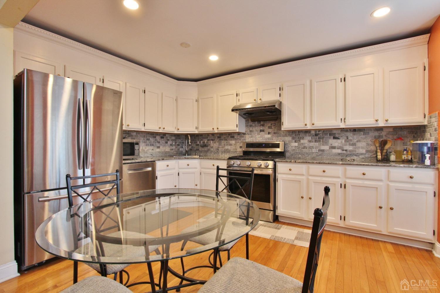 323 Hawthorne Road North Brunswick, NJ 08902 - Photo 7 of 29 a kitchen with stainless steel appliances granite countertop a stove a sink dishwasher a refrigerator a stove and white cabinets with wooden floor