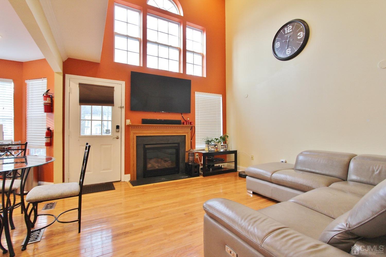 323 Hawthorne Road North Brunswick, NJ 08902 - Photo 10 of 29 a living room with furniture a fireplace and a floor to ceiling window
