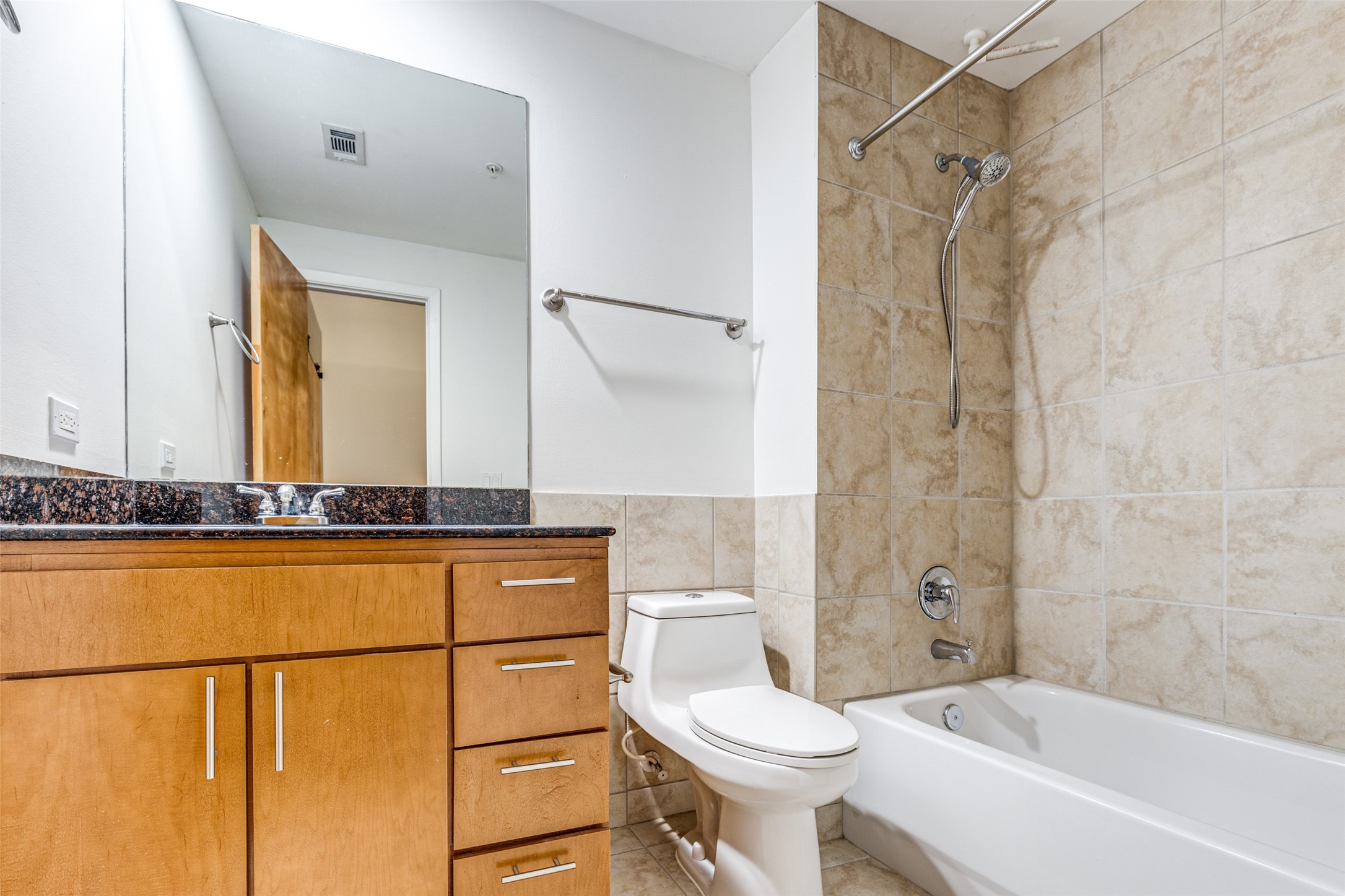 1312 Live Oak Street, Unit 223 Houston, TX 77003 - Photo 16 of 25 a bathroom with a granite countertop sink mirror vanity and toilet