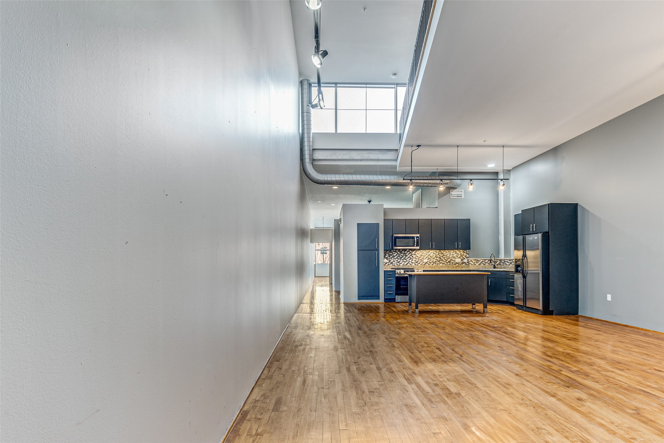 1312 Live Oak Street, Unit 223 Houston, TX 77003 - Photo 3 of 25 a view of a kitchen with a sink and wooden floor