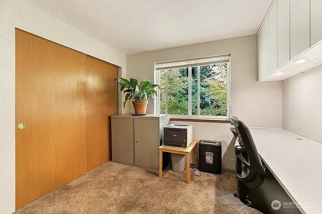 a view of a workspace with furniture and a window