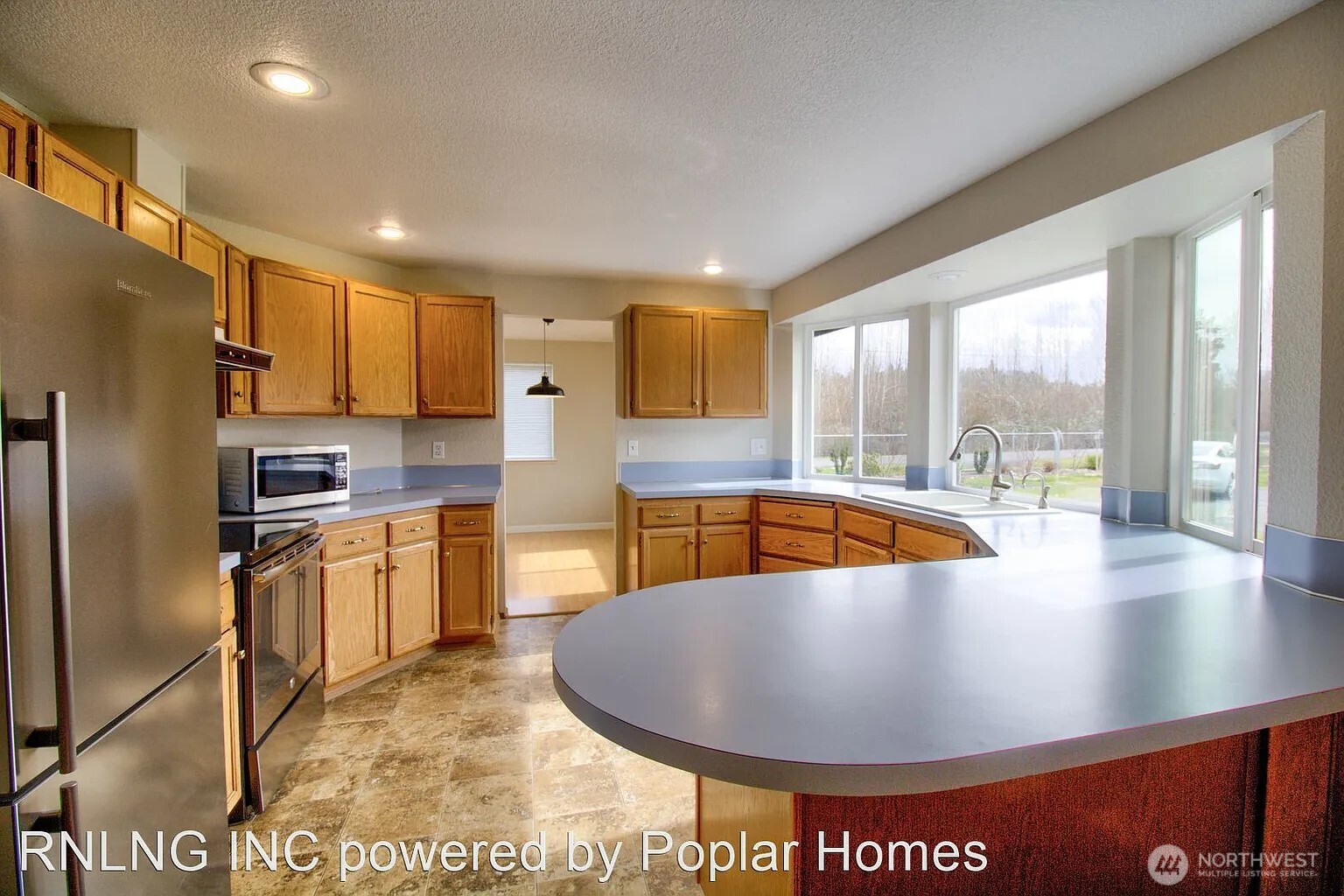 Undisclosed Address Redmond, WA 98052 - Photo 8 of 31 a view of a kitchen with stainless steel appliances granite countertop a stove a refrigerator a sink and a view of living room