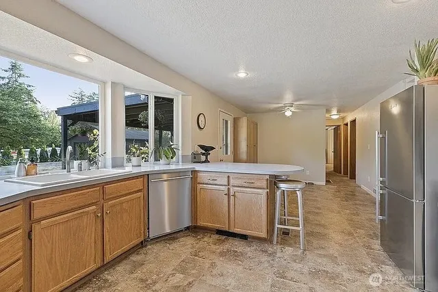 a large kitchen with kitchen island a sink stainless steel appliances and cabinets