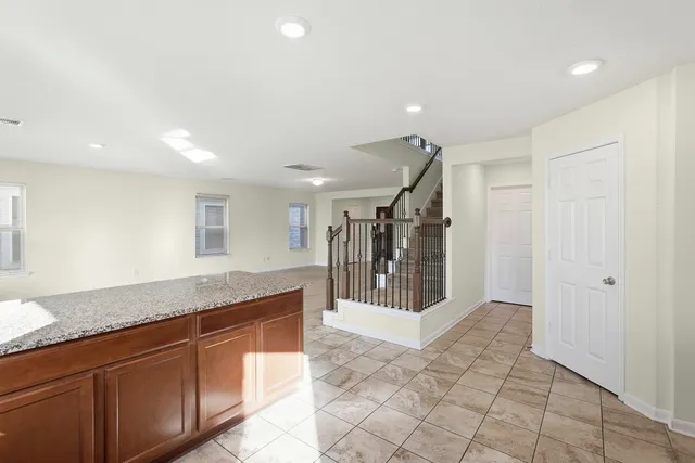a spacious bathroom with a granite countertop sink and a mirror