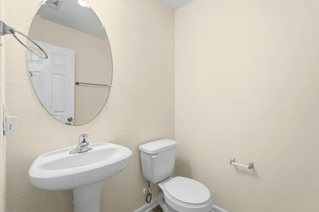 a bathroom with a toilet a sink and a mirror