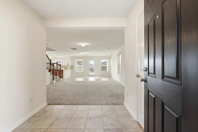 a view of a hallway to rooms and stairs