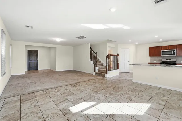 a view of large kitchen with a sink and a stove top oven