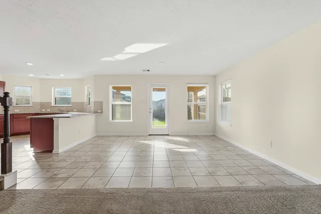 a view of an empty room with a kitchen
