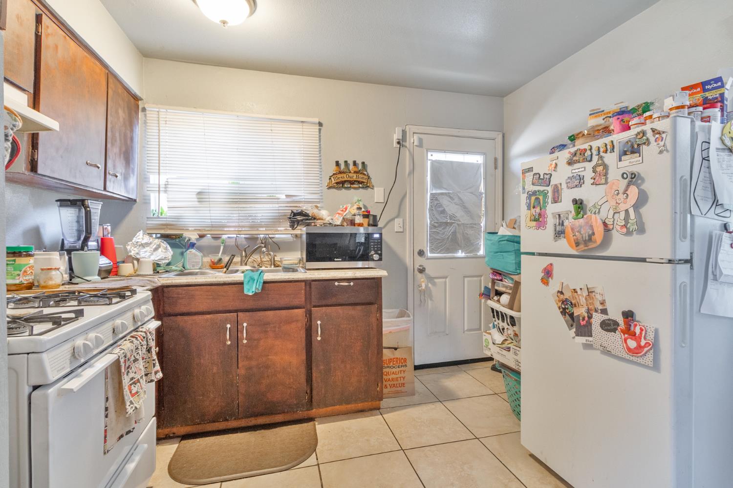 715 Faller Avenue Sanger, CA 93657 - Photo 29 of 40 a kitchen with a refrigerator a stove a cabinets and a window