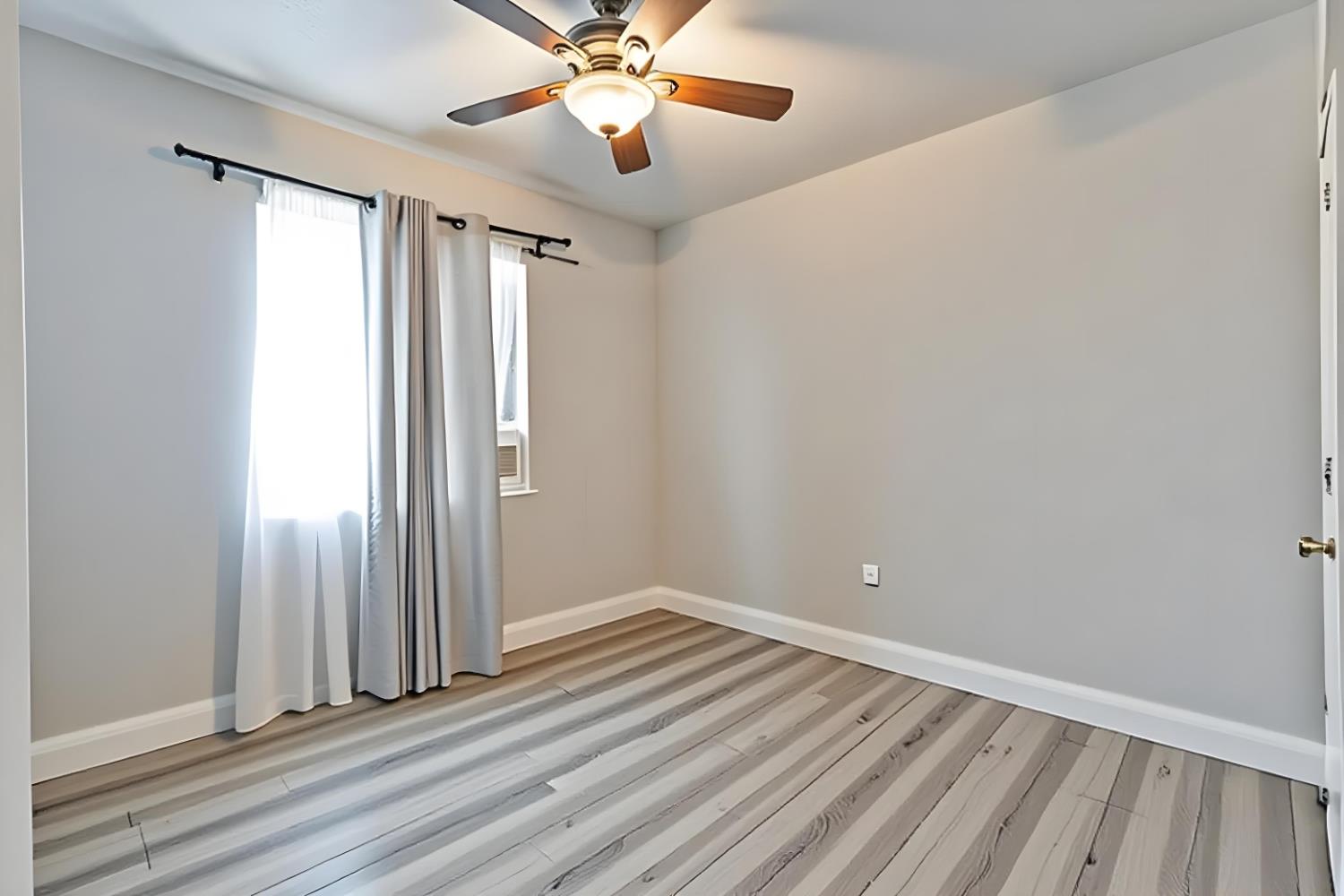 715 Faller Avenue Sanger, CA 93657 - Photo 32 of 40 a view of an empty room with wooden floor and a window