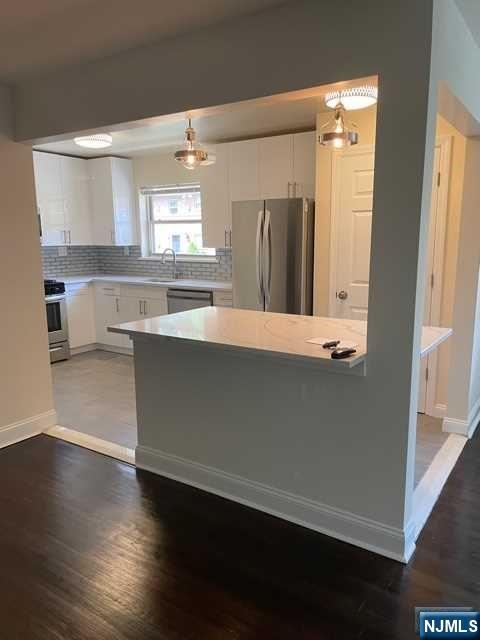 280-320 Oak Street, Unit 290D Ridgewood, NJ 07450 - Photo 4 of 20 an empty room with wooden floor and windows