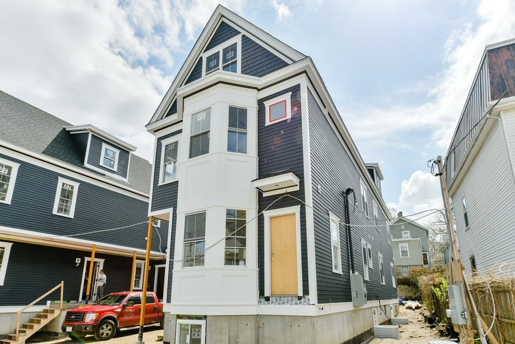 12 Ennis Road, Unit REAR Boston, MA 02119 - Photo 26 of 26 a front view of a residential apartment building with a yard
