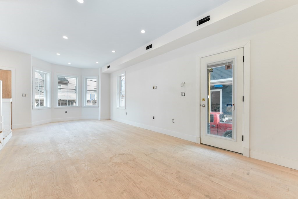 12 Ennis Road, Unit REAR Boston, MA 02119 - Photo 5 of 26 an empty room with an entryway and wooden floor