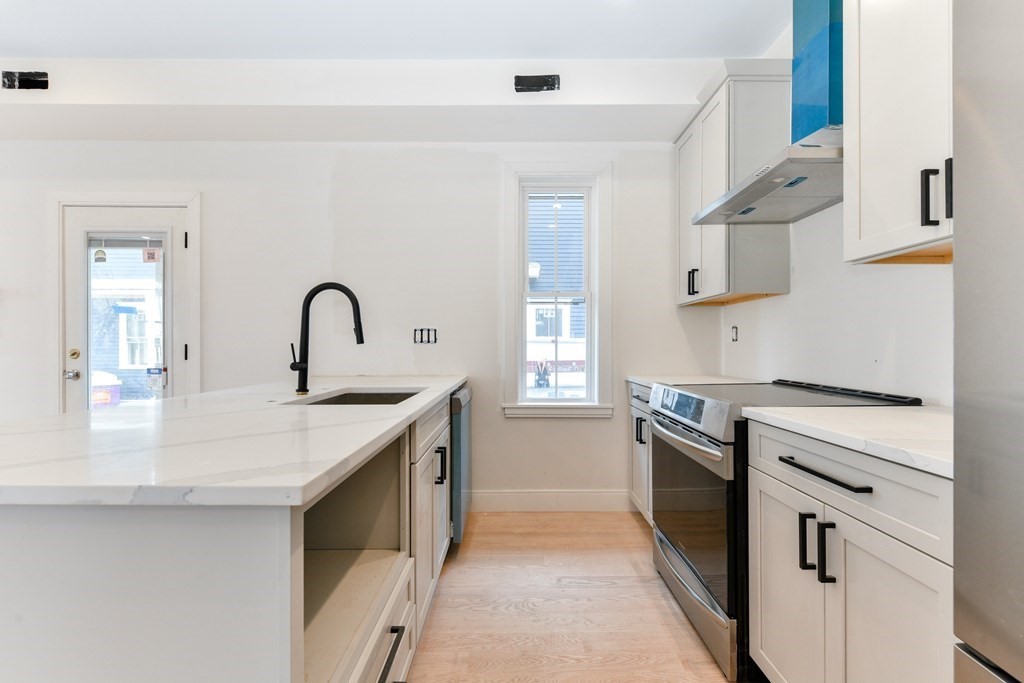 12 Ennis Road, Unit REAR Boston, MA 02119 - Photo 8 of 26 a kitchen with a sink stove and refrigerator