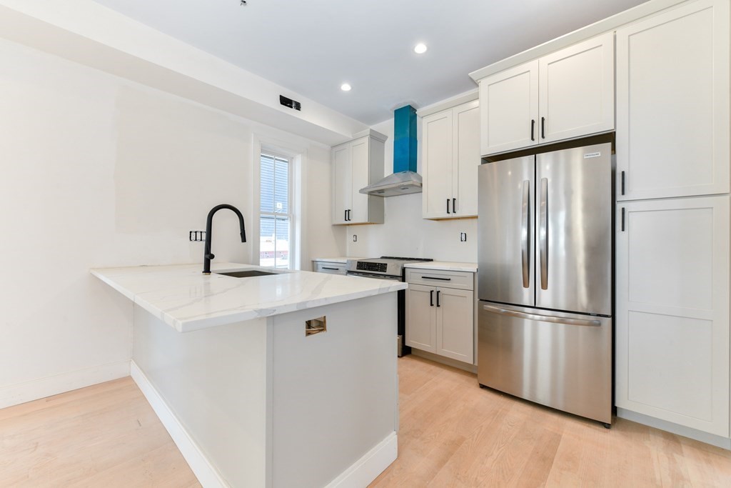12 Ennis Road, Unit REAR Boston, MA 02119 - Photo 10 of 26 a kitchen with a refrigerator sink and cabinets