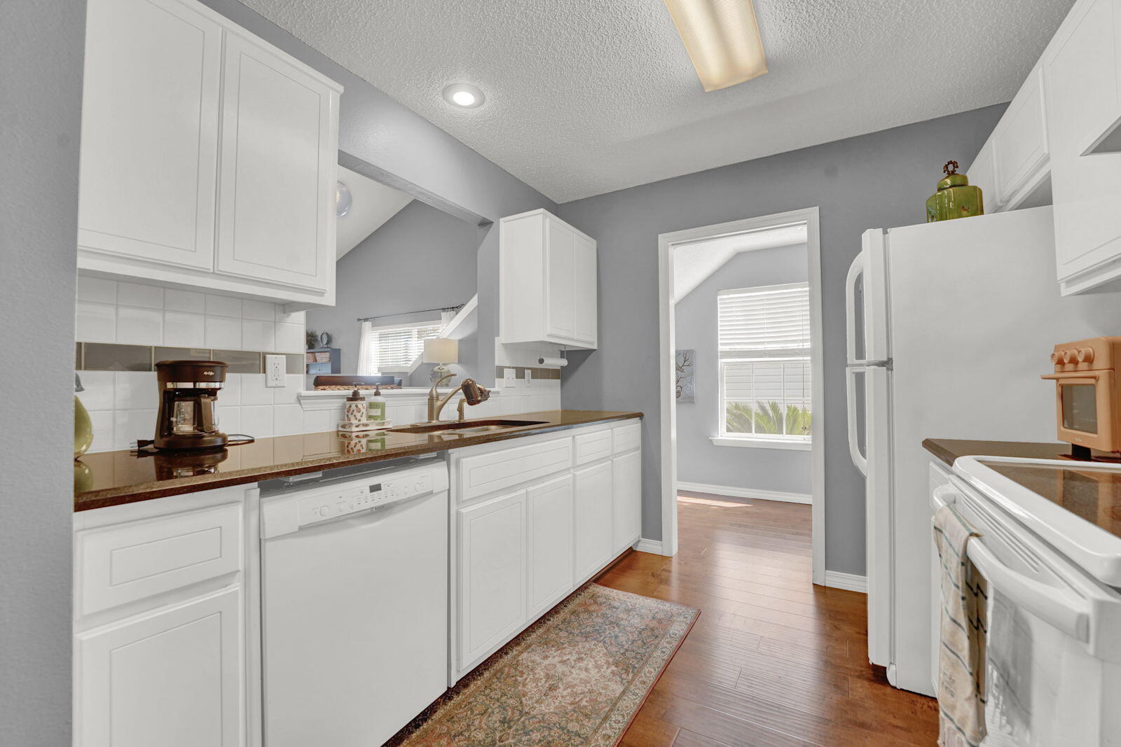 231 Vía Largo, Unit 39B Santa Rosa Beach, FL 32459 - Photo 8 of 50 a kitchen with granite countertop white cabinets and white appliances
