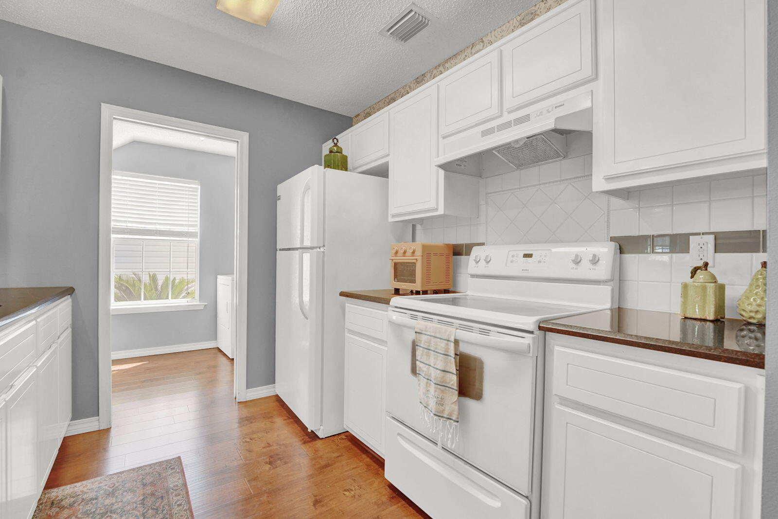231 Vía Largo, Unit 39B Santa Rosa Beach, FL 32459 - Photo 9 of 50 a kitchen with a refrigerator stove and white cabinets