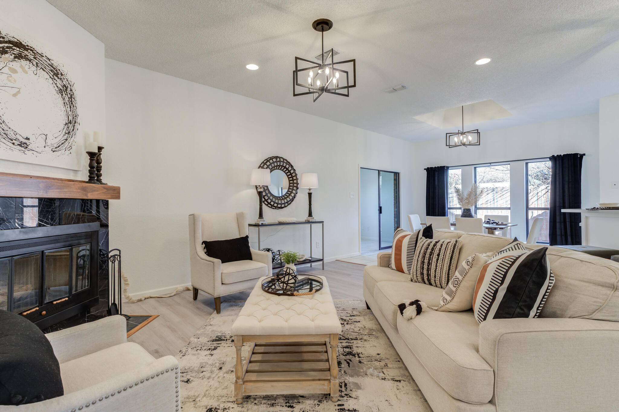 3602 101st Street Lubbock, TX 79423 - Photo 10 of 51 a living room with furniture a fireplace and a chandelier