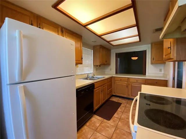 a kitchen with stainless steel appliances granite countertop a refrigerator a stove and a sink with wooden floor