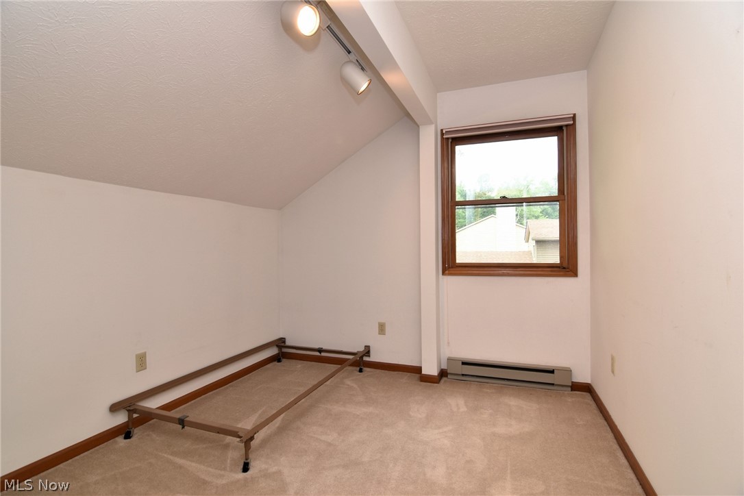 7655 Bellflower Road Mentor, OH 44060 - Photo 22 of 28 Additional living space with carpet flooring, a textured ceiling, a baseboard heating unit, and vaulted ceiling