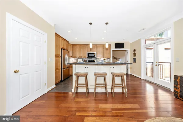 a large kitchen with granite countertop a sink and dishwasher a stove top oven with wooden floor