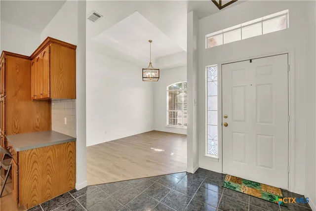 an empty room with wooden floor and cabinet