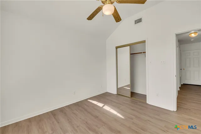 a view of empty room with wooden floor