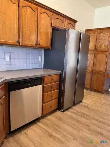 a kitchen with stainless steel appliances granite countertop a refrigerator and a sink
