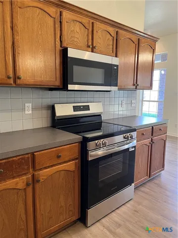 a kitchen with stainless steel appliances granite countertop a stove and a microwave