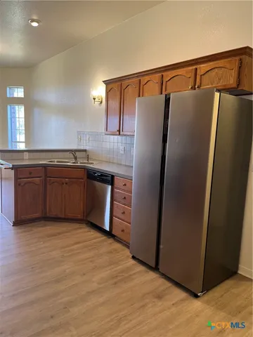 a kitchen with stainless steel appliances granite countertop a refrigerator and a sink