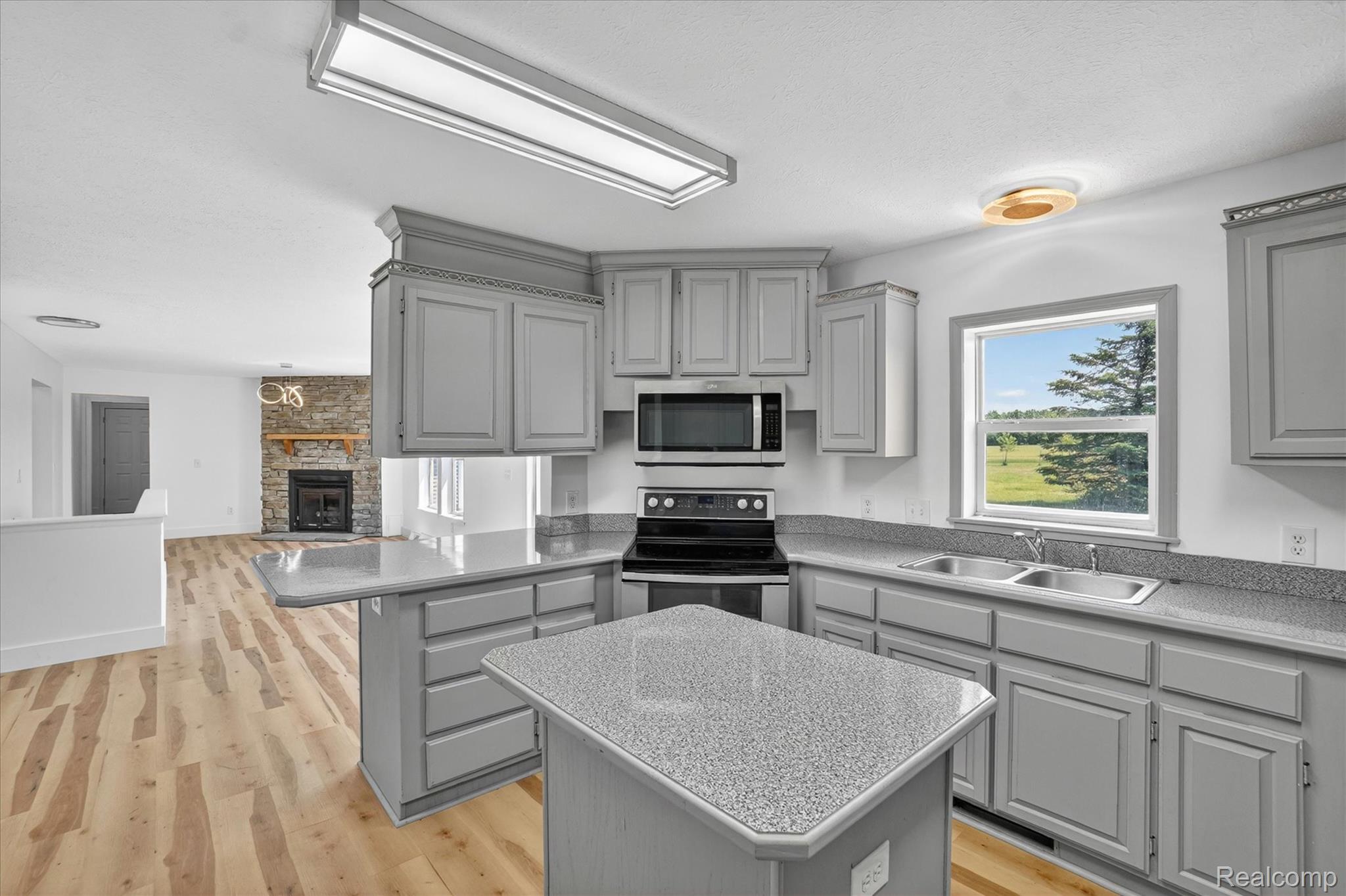 1400 North Every Road Mason, MI 48854 - Photo 14 of 33 Kitchen featuring light gray cabinetry, speckled countertops, and an integrated island