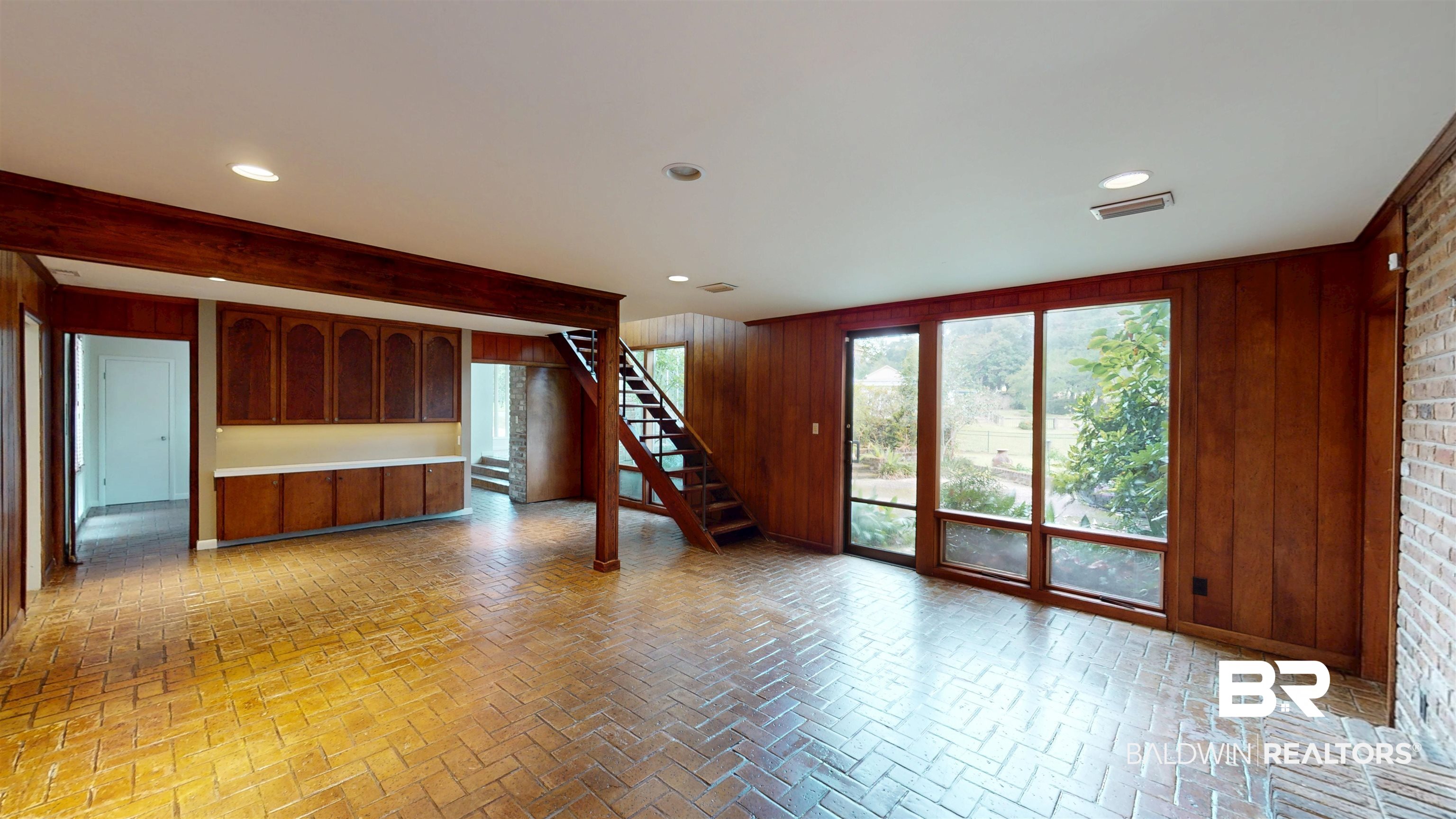 15 Spring Bank Road Mobile, AL 36608 - Photo 19 of 58 Unfurnished room with stairway, wood walls, brick flooring, and recessed lighting