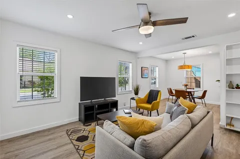 a living room with furniture and a ceiling fan