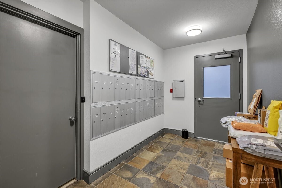 18 Dravus Street, Unit 207 Seattle, WA 98109 - Photo 32 of 34 a bathroom with a granite countertop sink a mirror and shower
