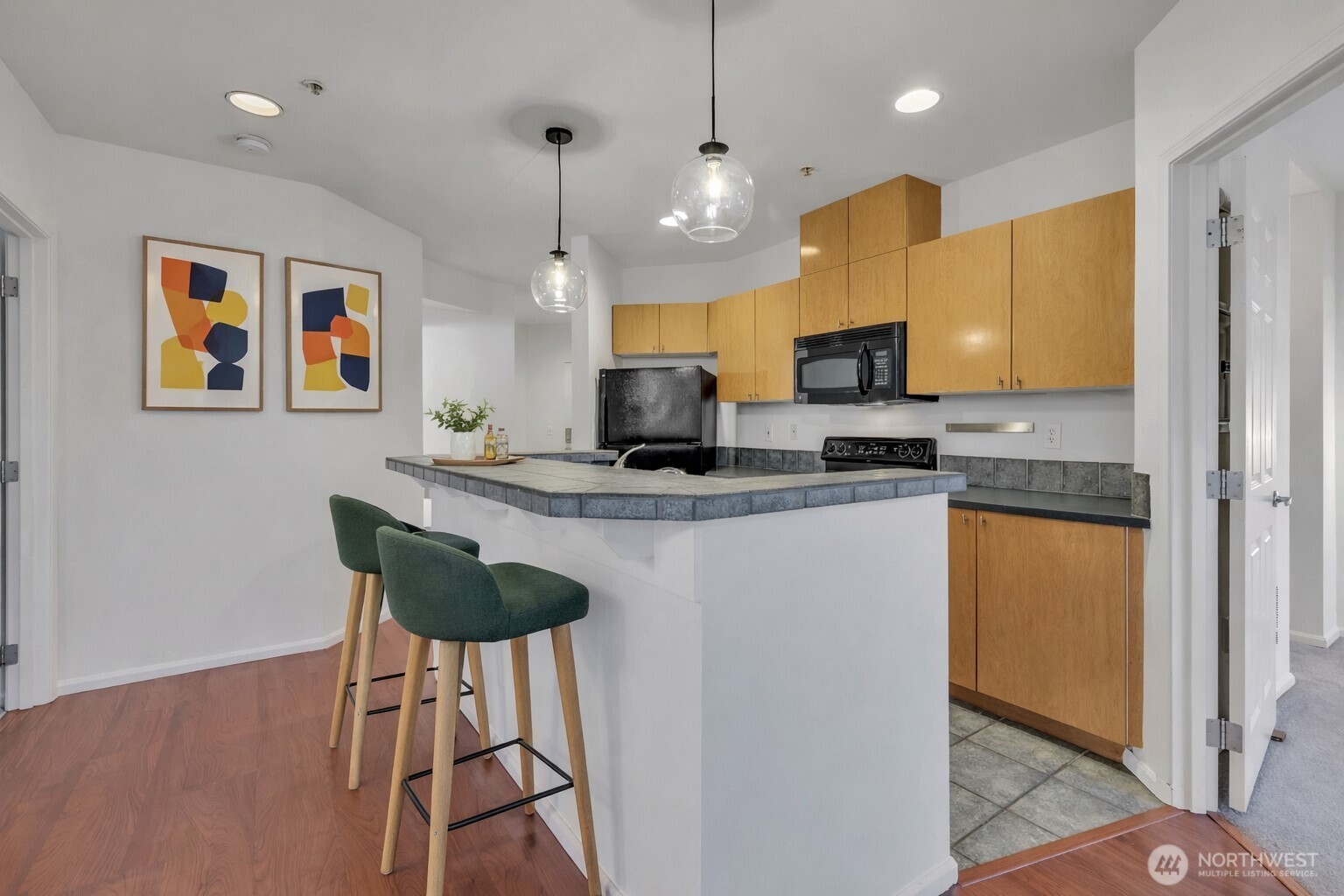 18 Dravus Street, Unit 207 Seattle, WA 98109 - Photo 6 of 34 a kitchen with stainless steel appliances granite countertop a refrigerator a stove a sink dishwasher and a microwave with wooden floor