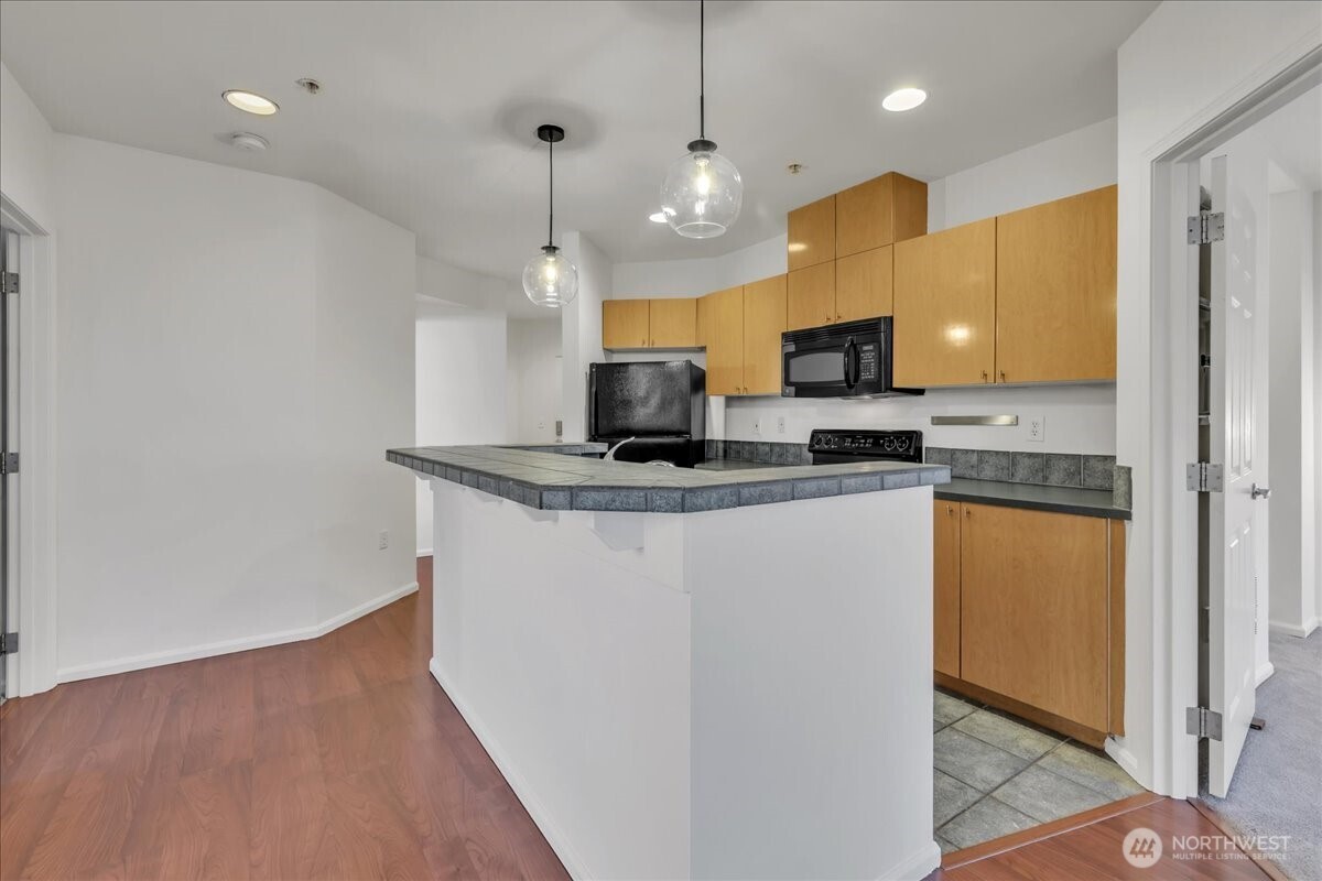 18 Dravus Street, Unit 207 Seattle, WA 98109 - Photo 7 of 34 a kitchen with stainless steel appliances granite countertop a refrigerator a stove a oven and a sink with granite countertops