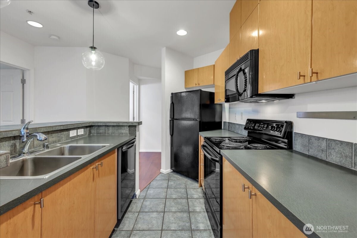 18 Dravus Street, Unit 207 Seattle, WA 98109 - Photo 8 of 34 a kitchen with stainless steel appliances granite countertop a sink a stove and a refrigerator
