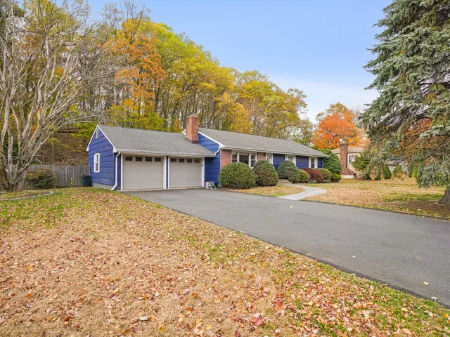 a front view of a house with a yard and mountain view