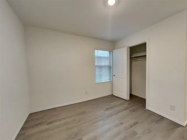 an empty room with wooden floor and closet