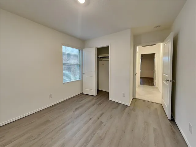 an empty room with wooden floor and closet
