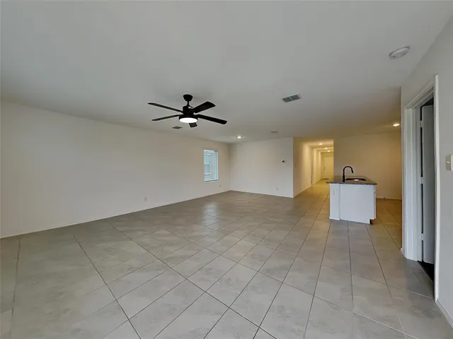 a view of a livingroom with a ceiling fan & entryway