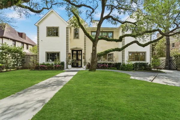 a front view of a house with a yard and trees