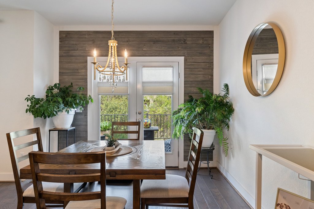 7409 Merrick Lane, Unit 40 Austin, TX 78745 - Photo 12 of 37 a dining room with furniture potted plants and wooden floor