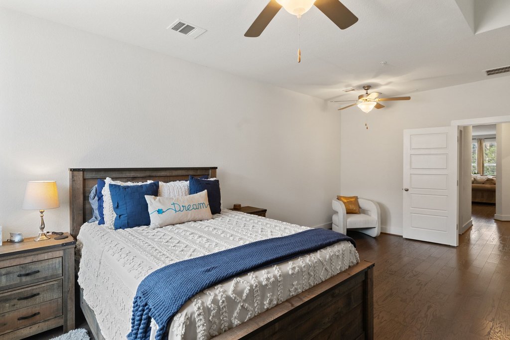 7409 Merrick Lane, Unit 40 Austin, TX 78745 - Photo 14 of 37 a bedroom with a bed and wooden floor