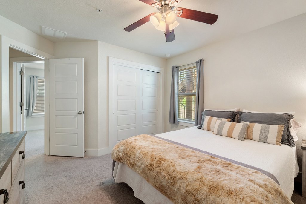 7409 Merrick Lane, Unit 40 Austin, TX 78745 - Photo 24 of 37 a bedroom with a bed and a chandelier